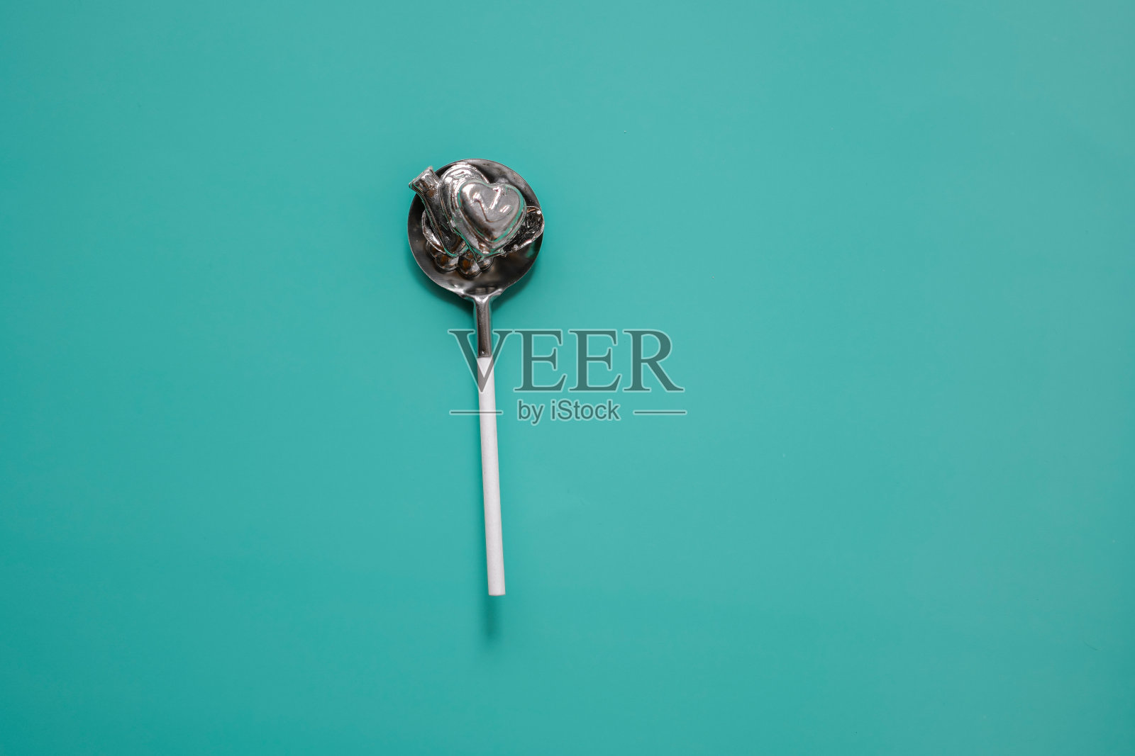 绿松石背景上的锡勺子和锡小雕像。新年晚会铅浇筑套装。德国圣诞传统习俗照片摄影图片