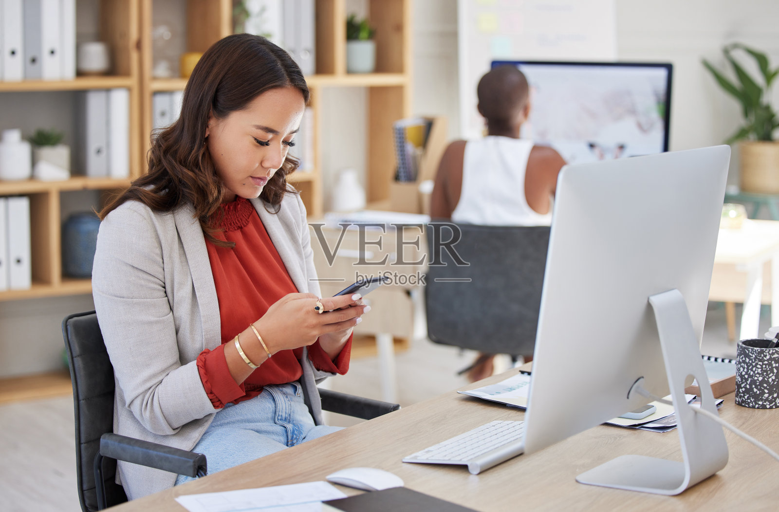 办公室女职员，在公司大楼工作时，负责处理和阅读电话留言和沟通。年轻的商业主管和专业的职场女孩在看智能手机上的文字。照片摄影图片