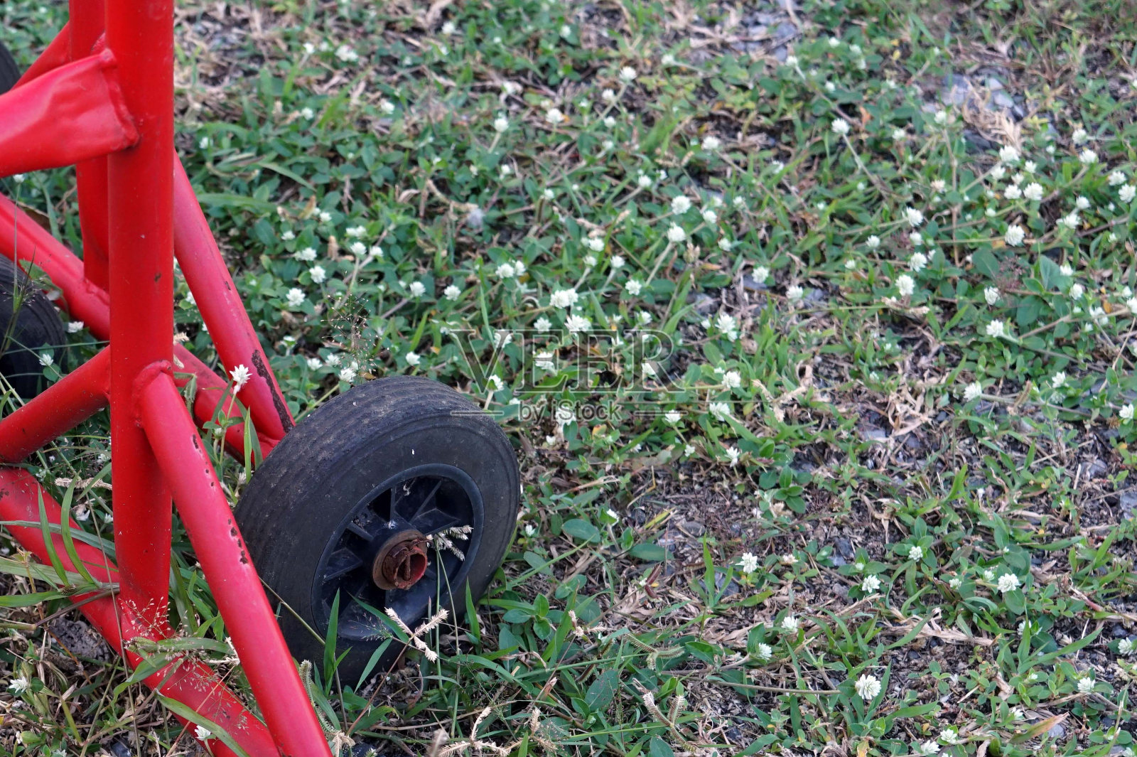 旧的黑色车轮在草地公园里阻挡交通。照片摄影图片
