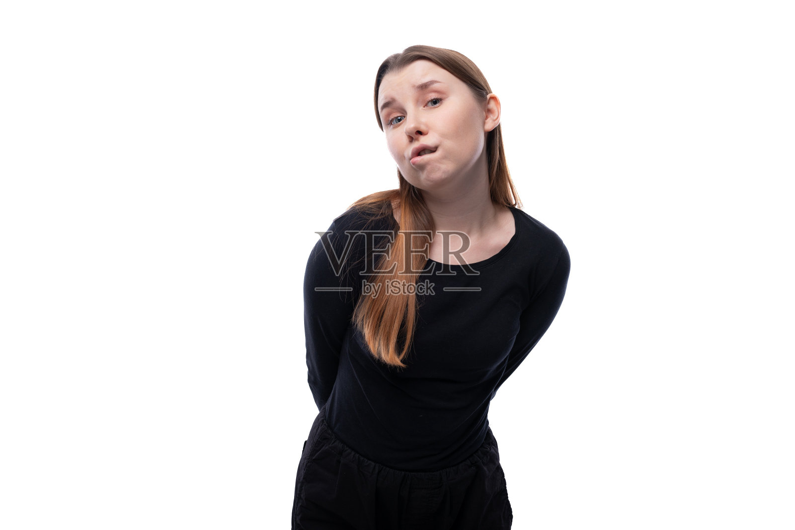 自信的学龄女孩，棕色头发，白色画室背景照片摄影图片