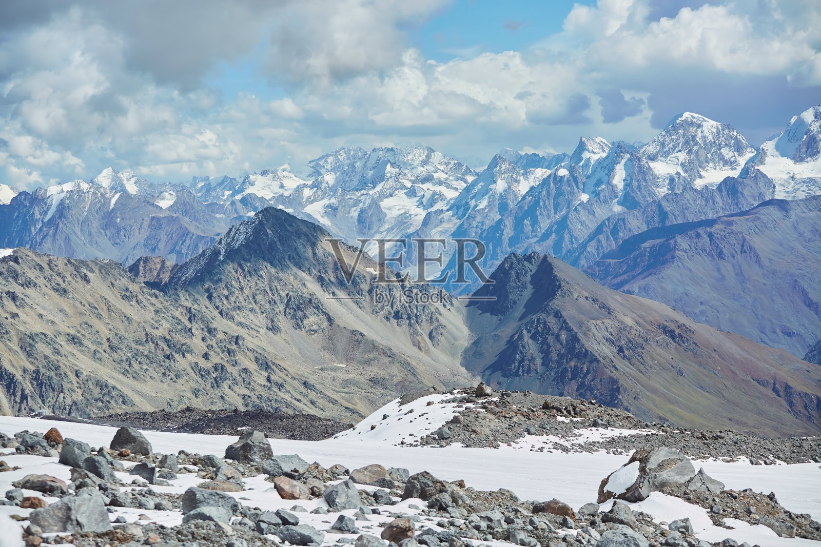 冬季山地景观。高山上覆盖着皑皑白雪。越过群山，天空湛蓝明亮照片摄影图片
