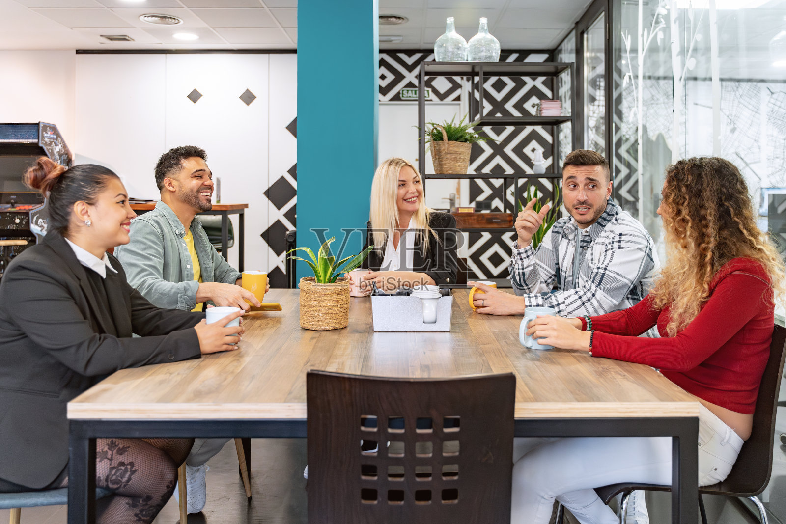 在办公室喝咖啡休息时，同事们微笑着聊天。照片摄影图片