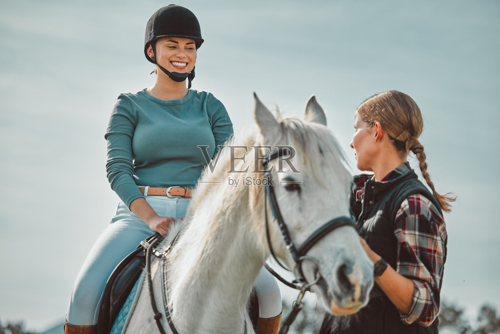 在乡村，马、骑师和骑手与女教练一起训练骑马者。照片摄影图片