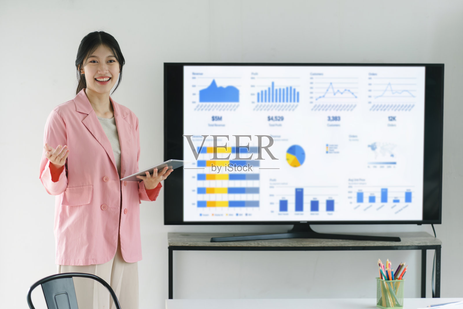 一个微笑的，自信的女商人的肖像，解释销售推销，商业投资计划，或公司战略。工作坊，培训教练，呈现报告概念照片摄影图片