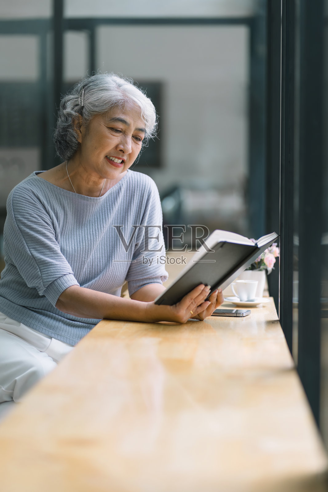 亚洲老年妇女在咖啡馆放松阅读照片摄影图片