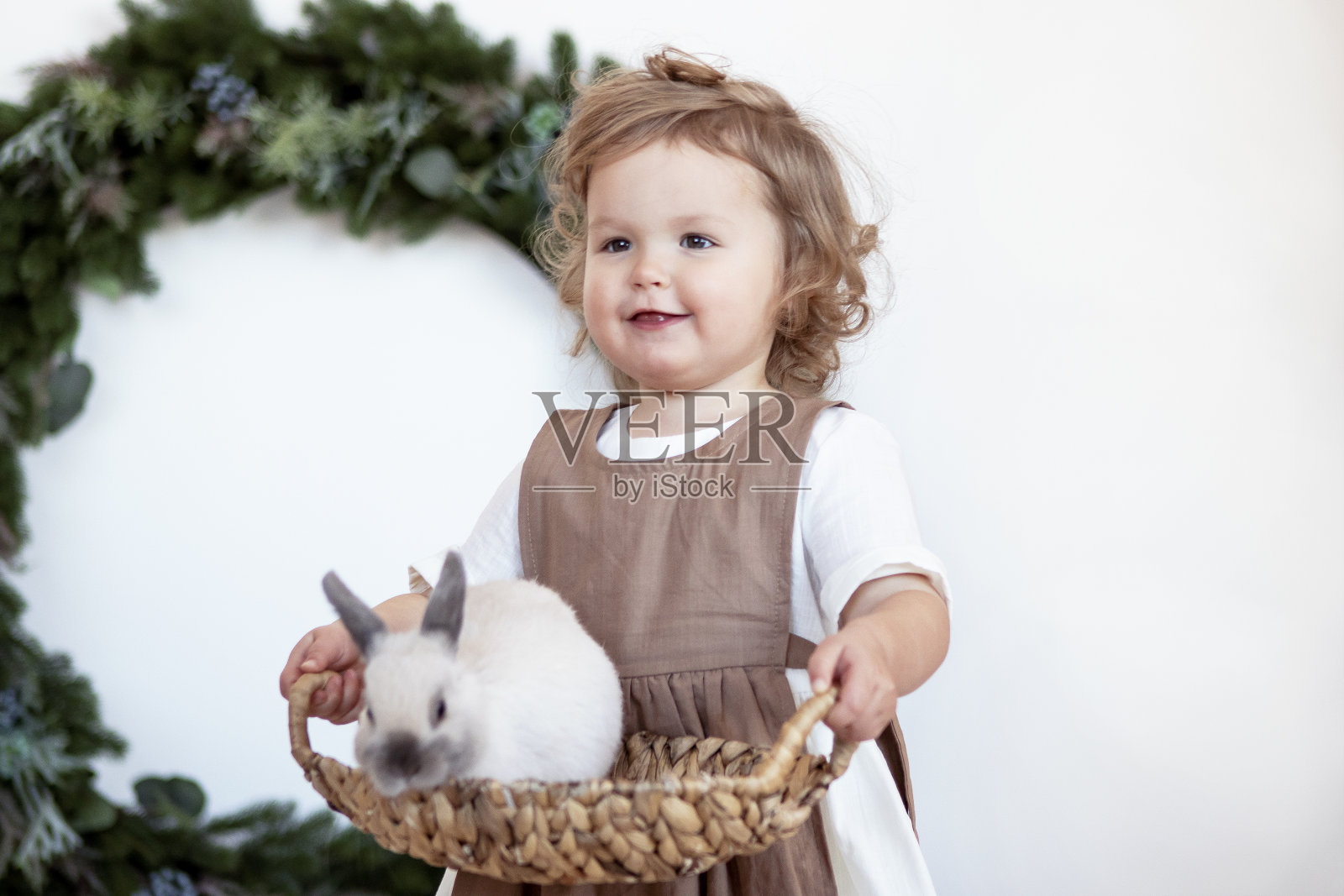 年轻的金发女孩手里拿着兔子。圣诞节的概念照片摄影图片