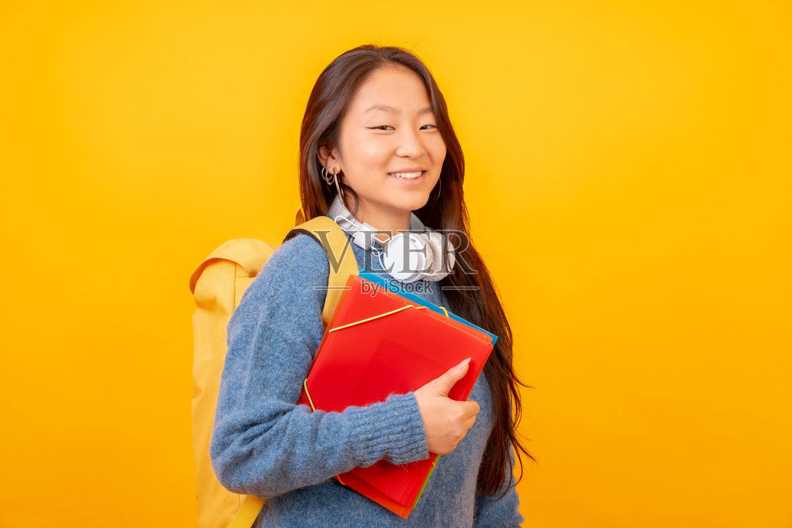 中国学生带着耳机、书包和文件夹照片摄影图片