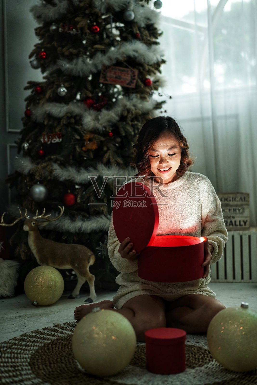 女人打开圣诞礼物时的喜悦照片摄影图片