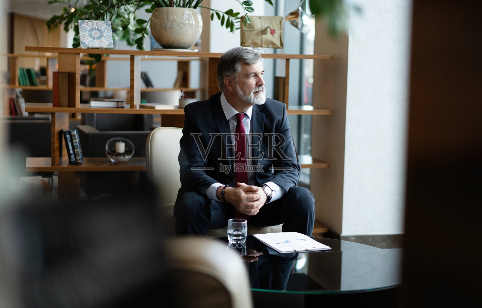 商业肖像——坐在办公室大厅里的成熟商人。男性行政人员在办公室休息室休息照片摄影图片