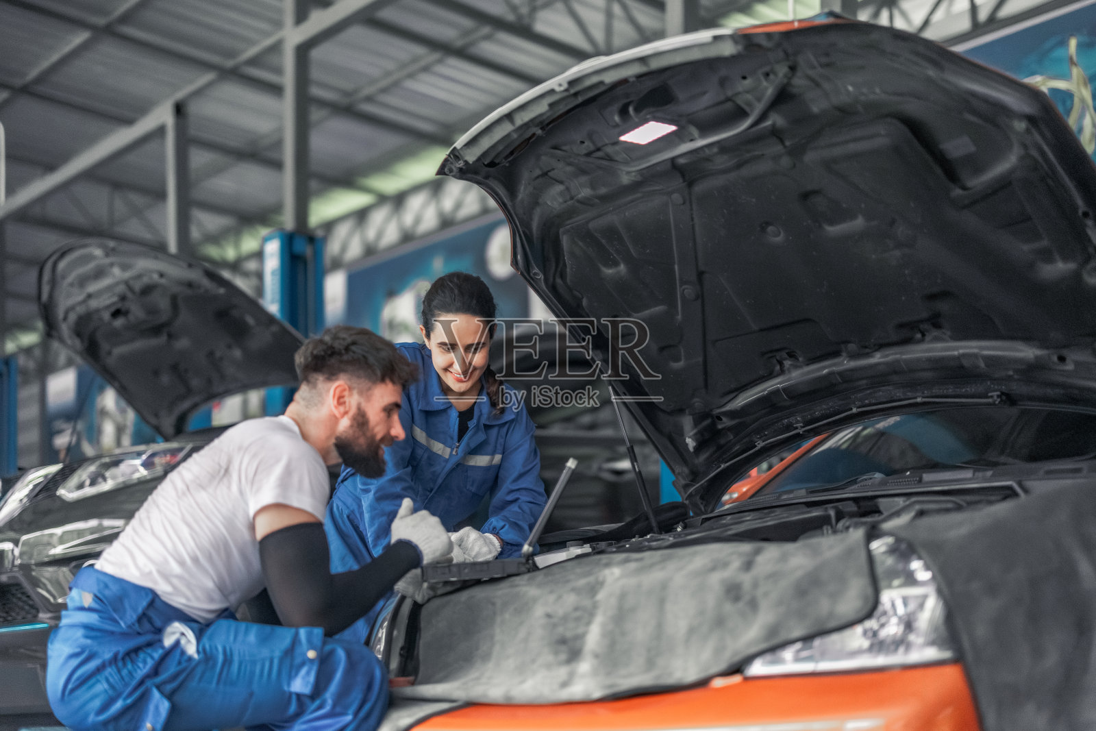 汽车技师使用电脑诊断分析、修理发动机，确保最佳性能照片摄影图片