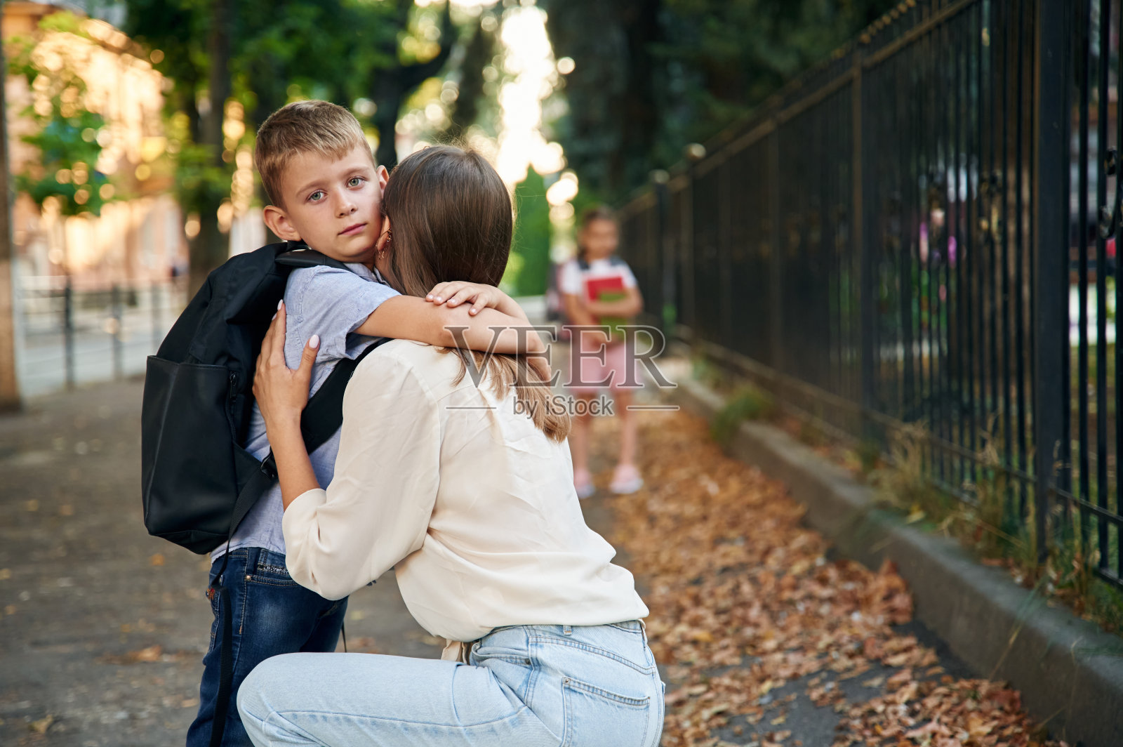 带着两个孩子去上学的女人，教育的概念照片摄影图片