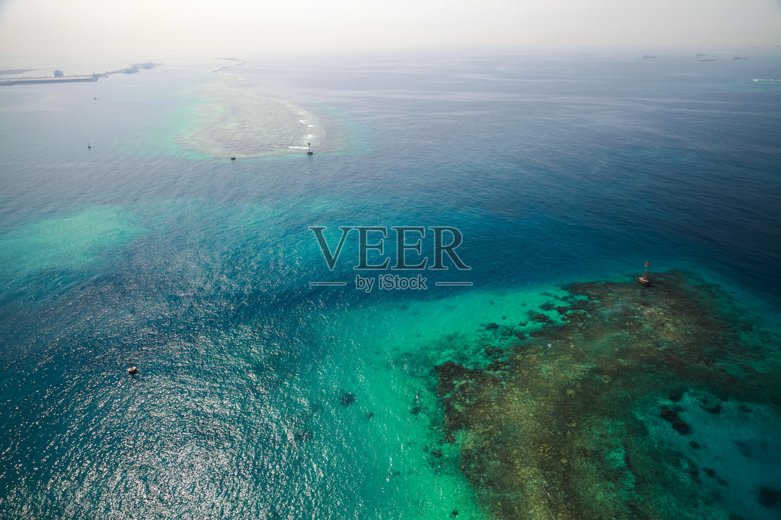 沙特阿拉伯的波斯湾鸟瞰图，浅水区中的红色灯塔照片摄影图片