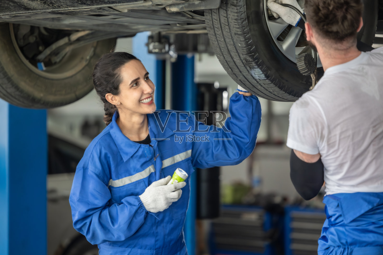 汽车技师在车库中分析并解决车轮问题，使用精密工具进行优化校准照片摄影图片