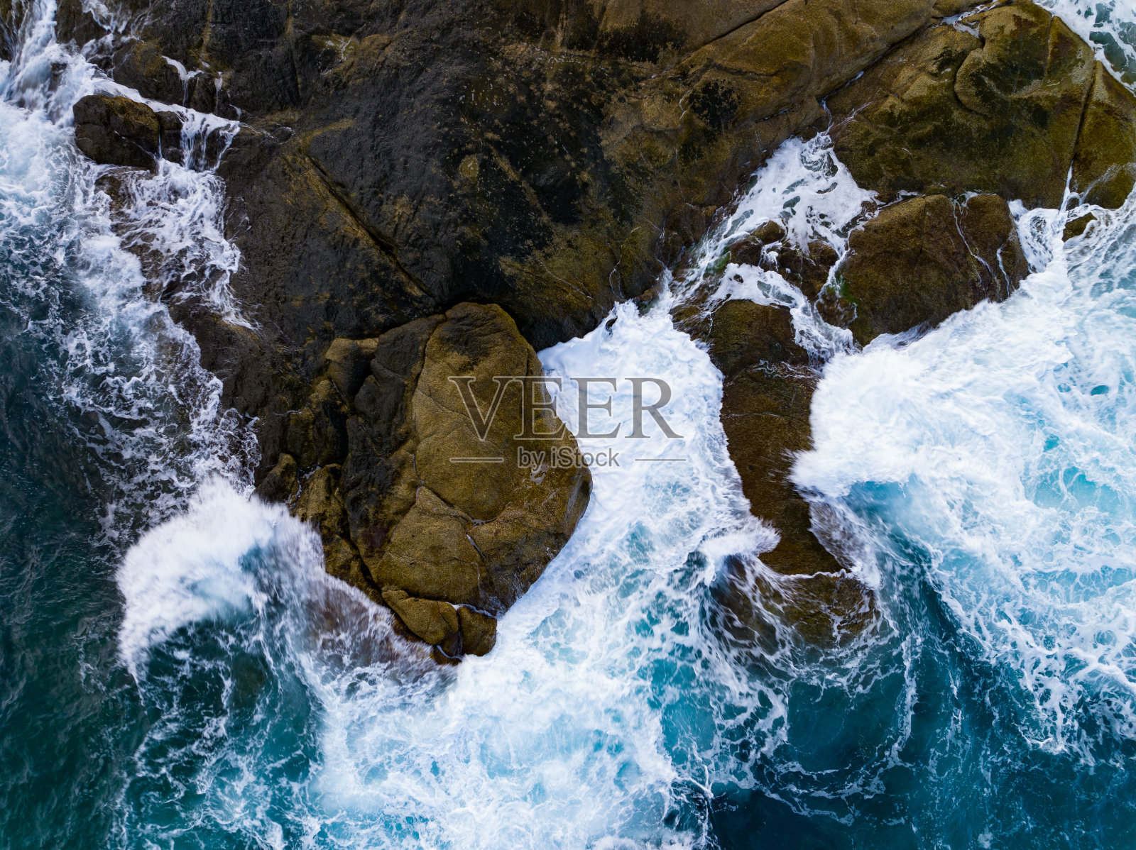 鸟瞰海岸与大浪冲击岩石悬崖。美丽的波浪海面在阳光明媚的日子夏天的背景，令人惊叹的海景顶视图海岸景观视图照片摄影图片