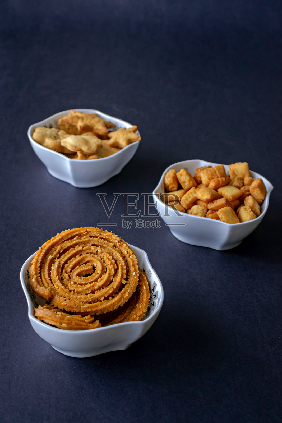 各种各样的，新鲜的排灯节小吃或faral项目填在白色碗与清晰的黑色背景。照片摄影图片