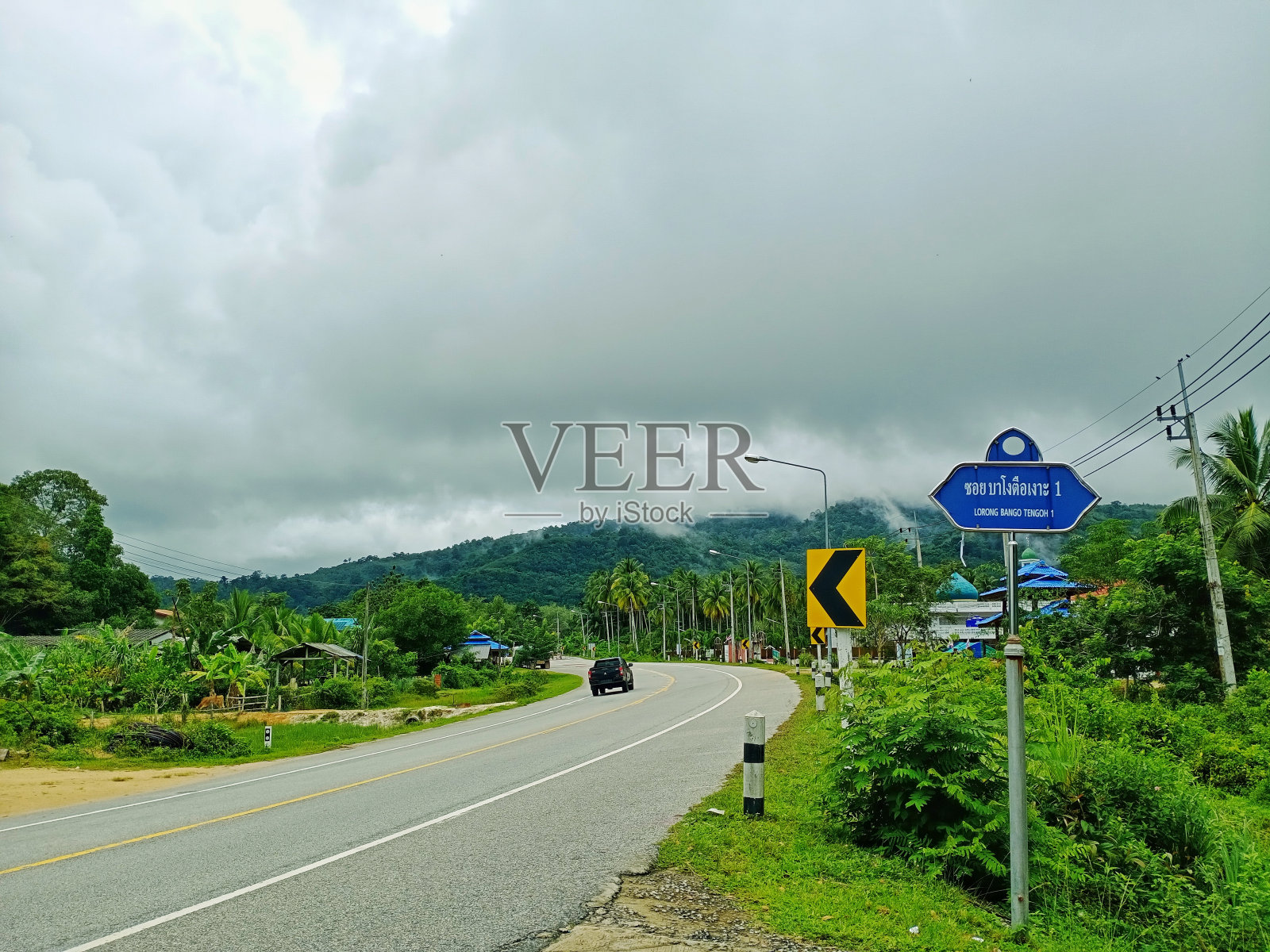 白天，在白云的笼罩下，群山附近树木的绿色自然景观照片摄影图片