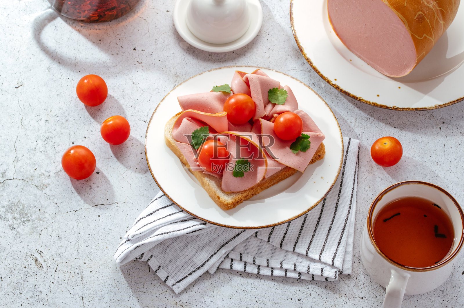 桌子上白色盘子里的火腿三明治照片摄影图片