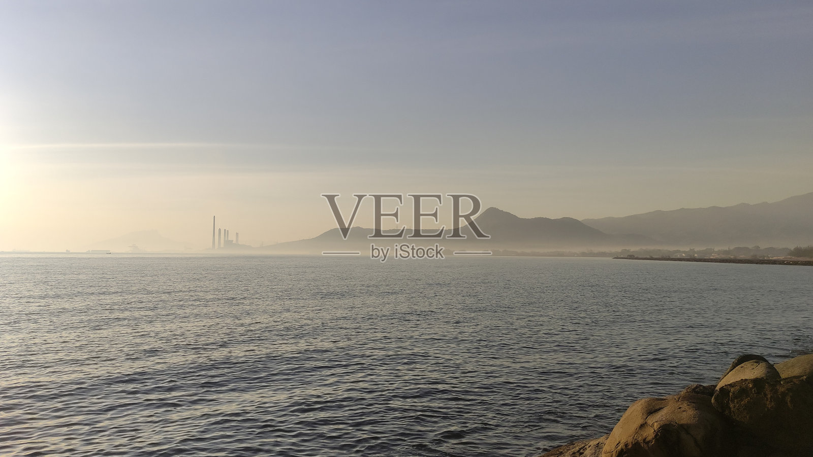 平静的海水适合海港，可欣赏海滨山丘的景色照片摄影图片