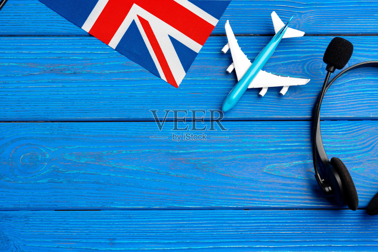 蓝色木制背景上的英国国旗和玩具飞机照片摄影图片
