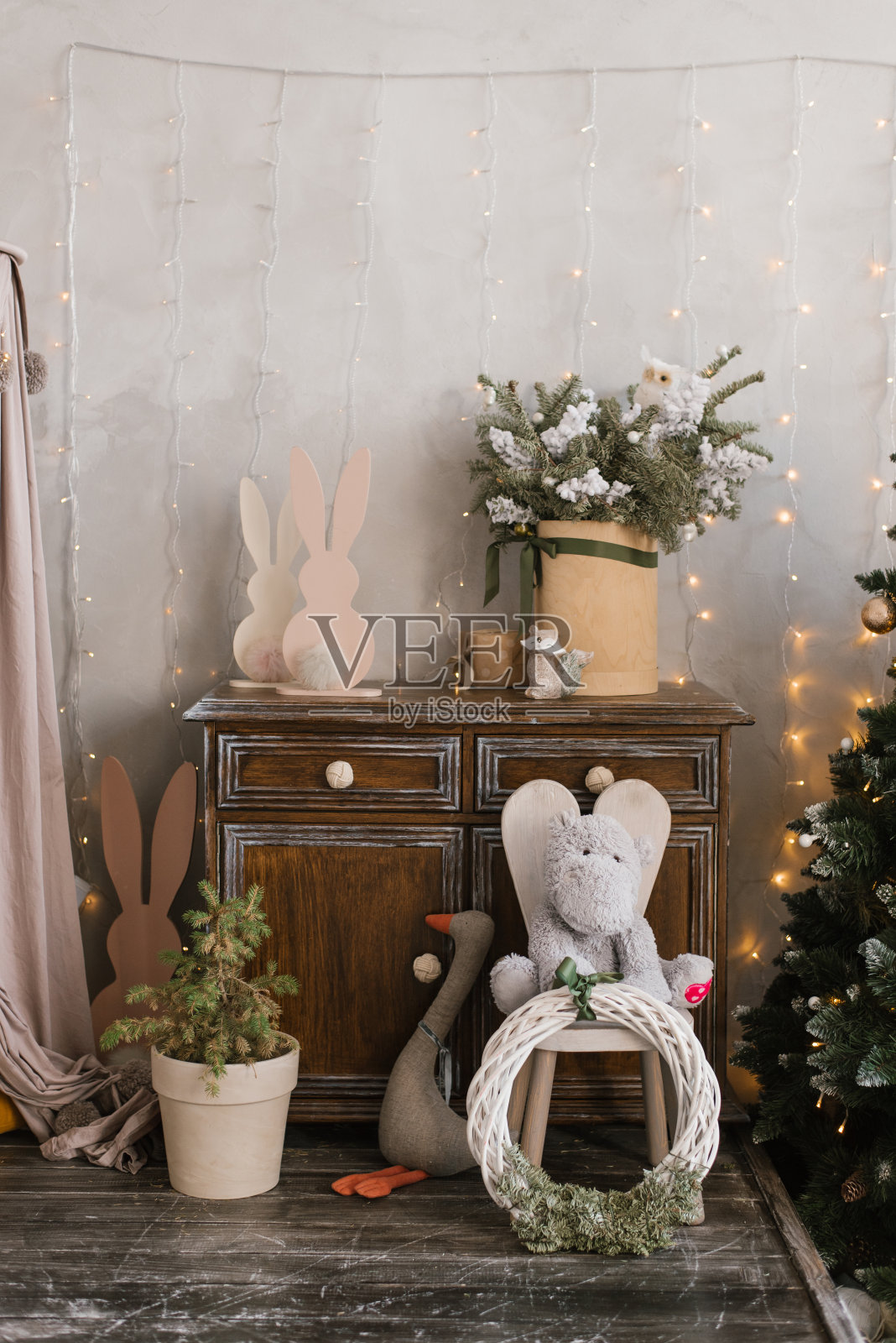 孩子们房间的圣诞装饰:玩具，花盆里的树，圣诞花环和彩灯照片摄影图片