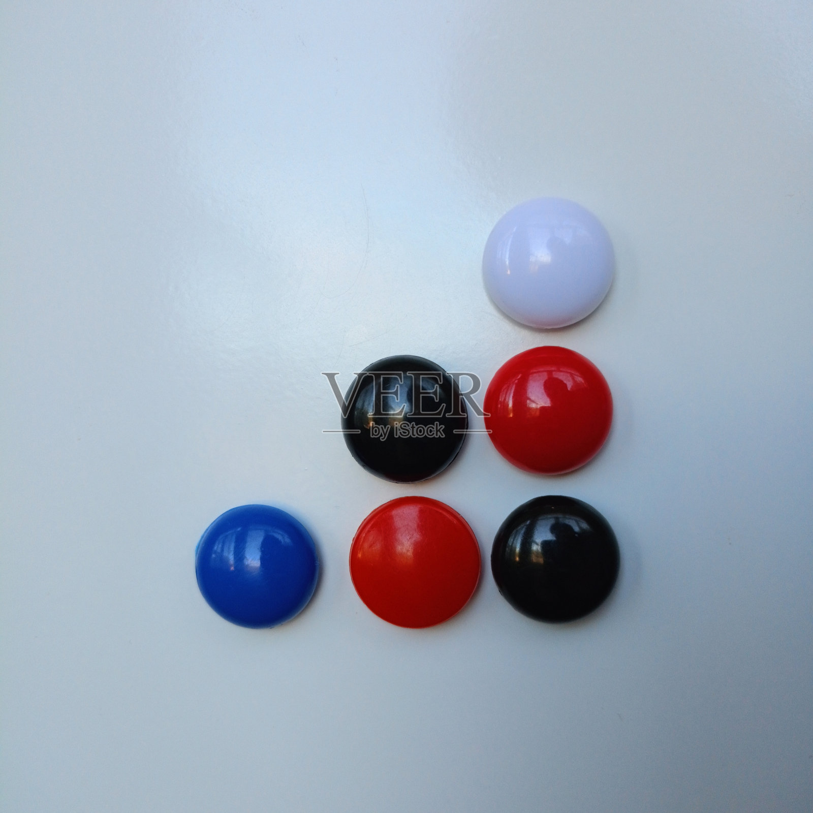 在白色金属背景上用彩色小磁铁做成的图形照片摄影图片