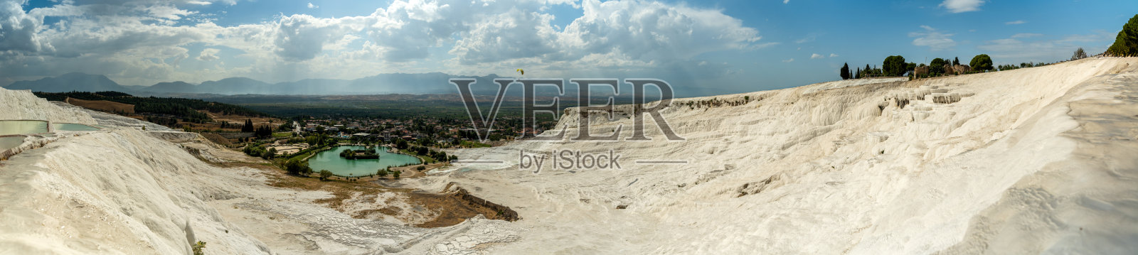 从上面俯瞰Pamukkale的白色石灰华及其底部的湖泊。照片摄影图片