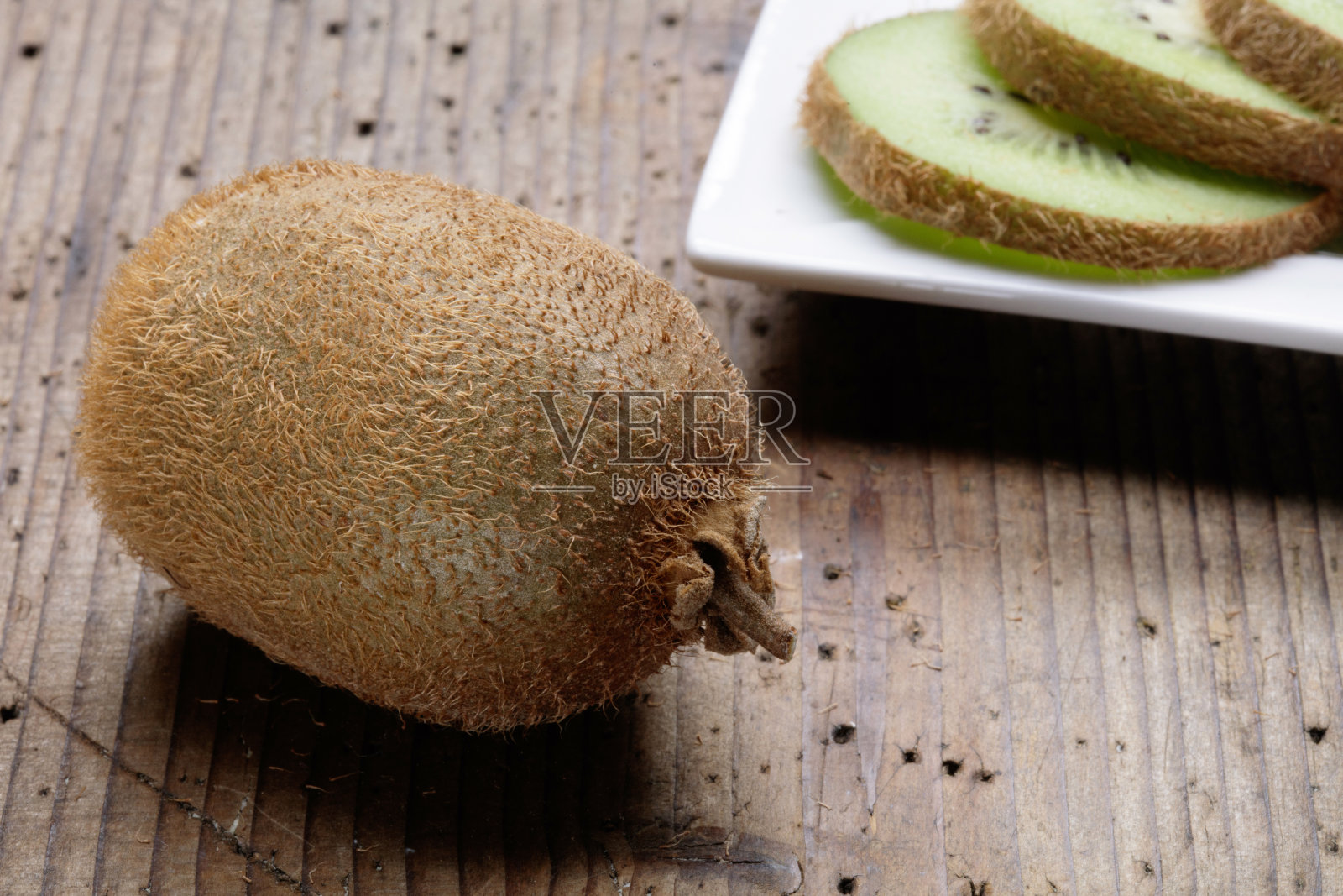 从正面看木桌上的猕猴桃片照片摄影图片