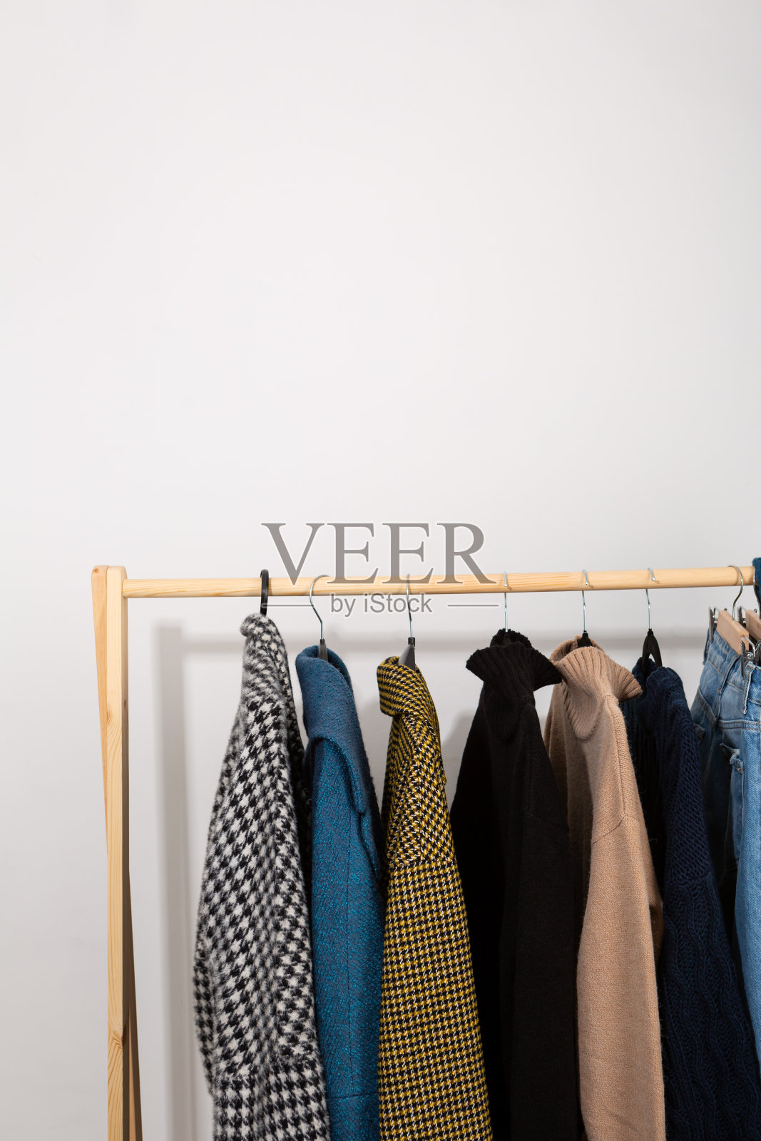 冬季衣橱里温暖的牛仔裤和大衣挂在衣架上，衣服慢时尚照片摄影图片