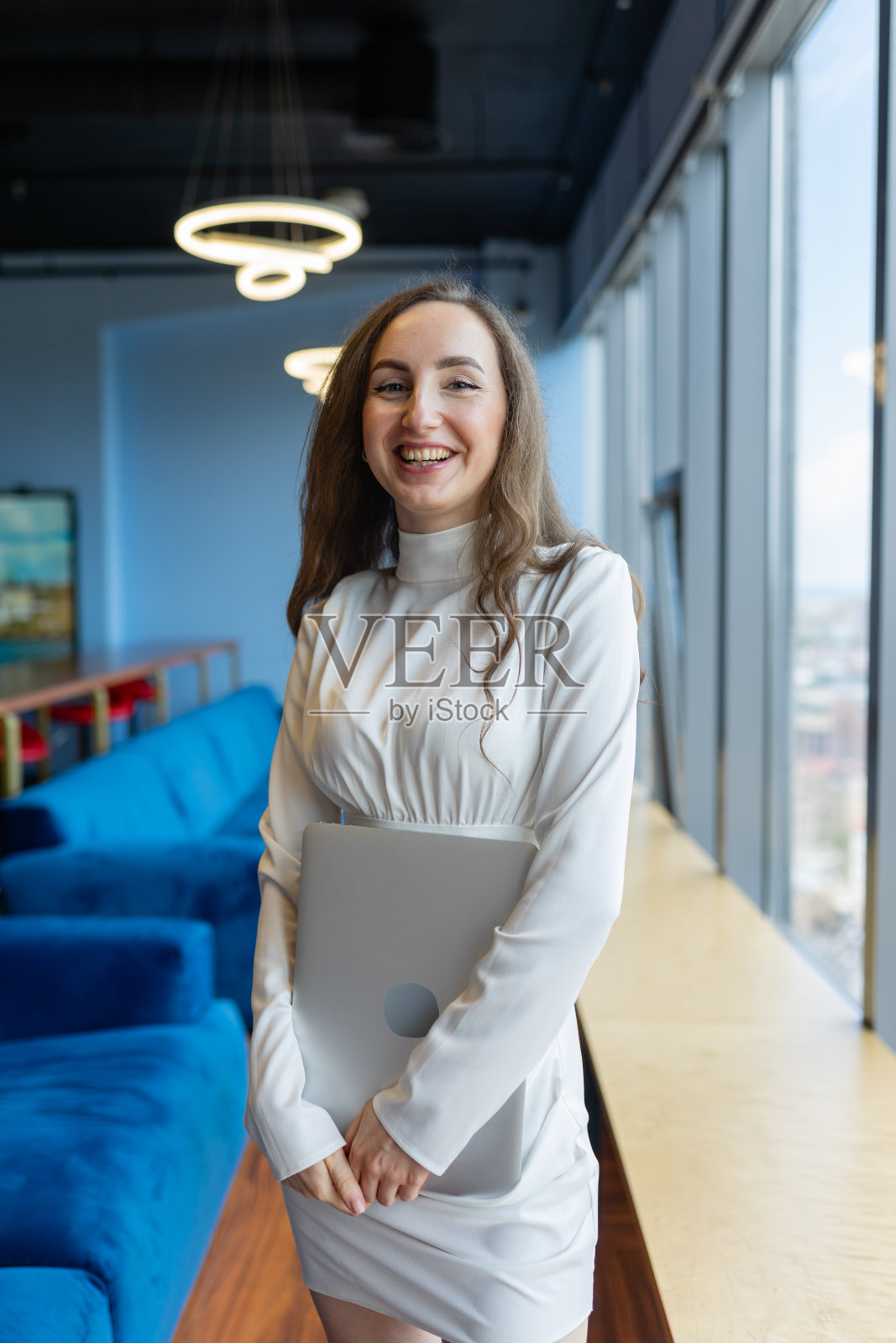 一头蓬松的黑发女CEO在办公室里露出露齿的微笑照片摄影图片