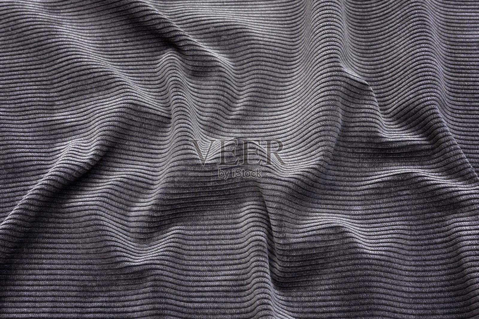 自然黑色面料的抽象背景纹理。天然棉或亚麻、丝绸或缎子、羊毛或针织纺织材料的织物质地。豪华的深灰色帆布背景。照片摄影图片