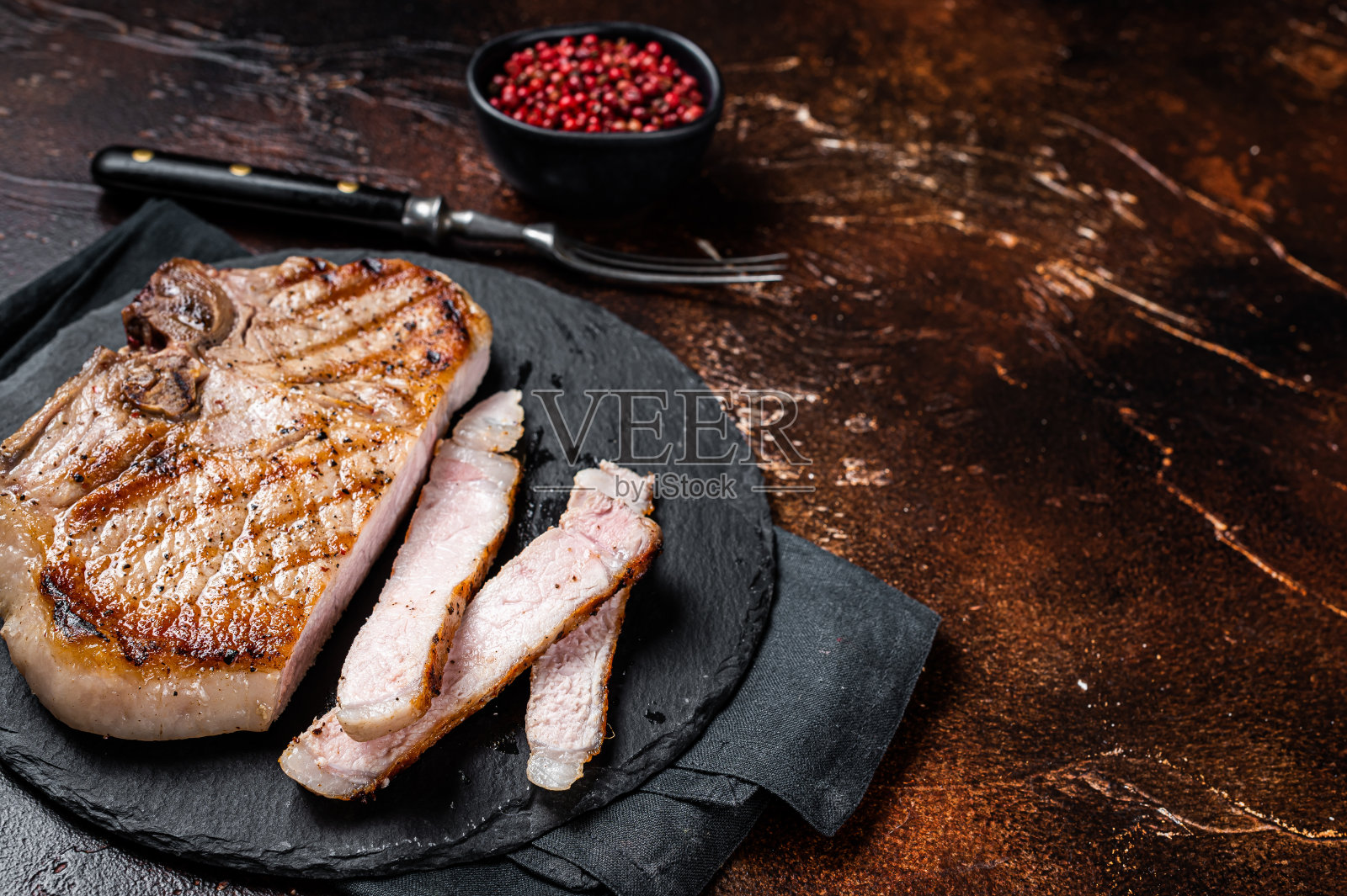 烤烧烤猪排或丁骨肉牛排切在板上。黑暗的背景。前视图。本空间照片摄影图片