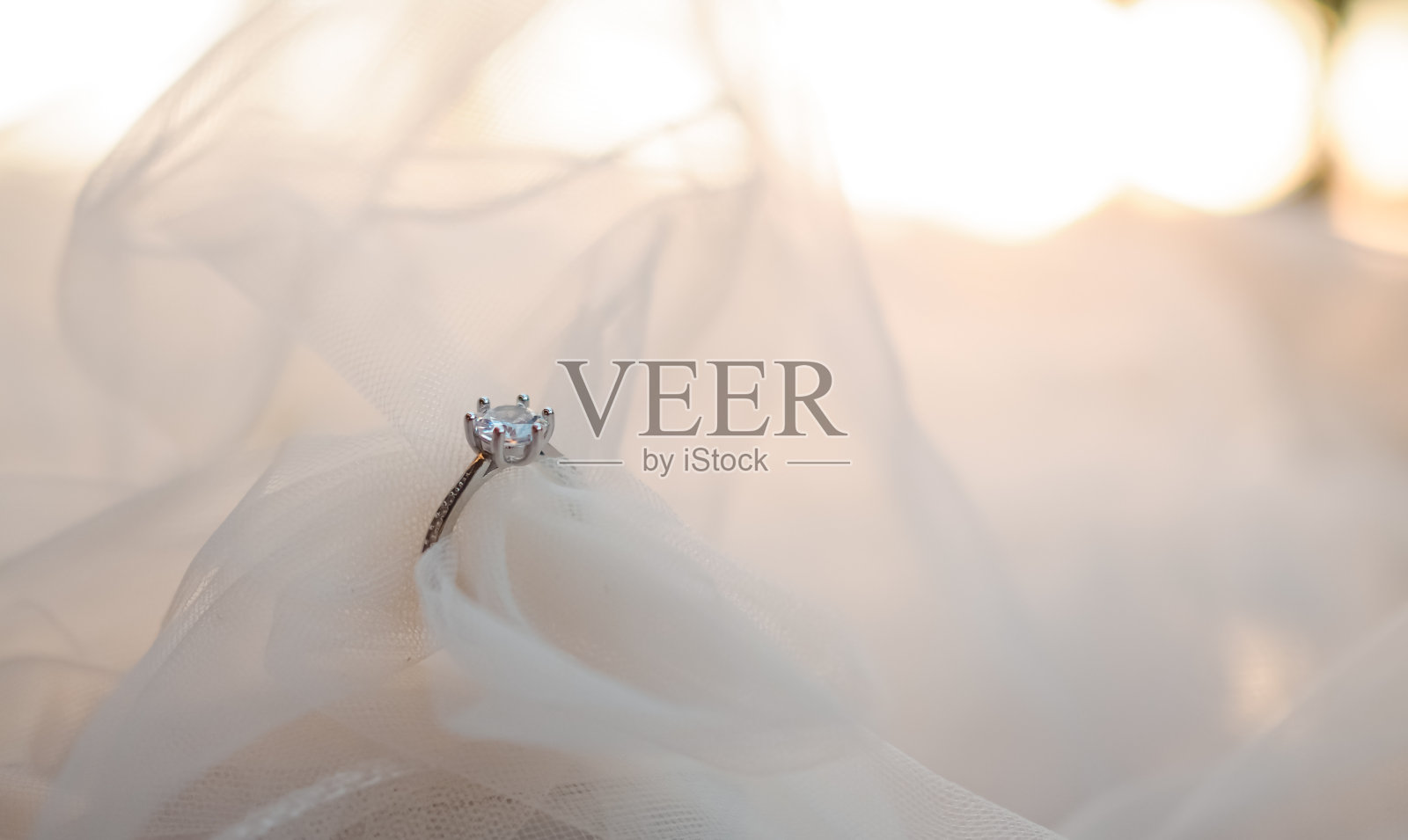 新娘头纱上的订婚钻戒。婚庆配件，情人节和婚庆日的概念。照片摄影图片