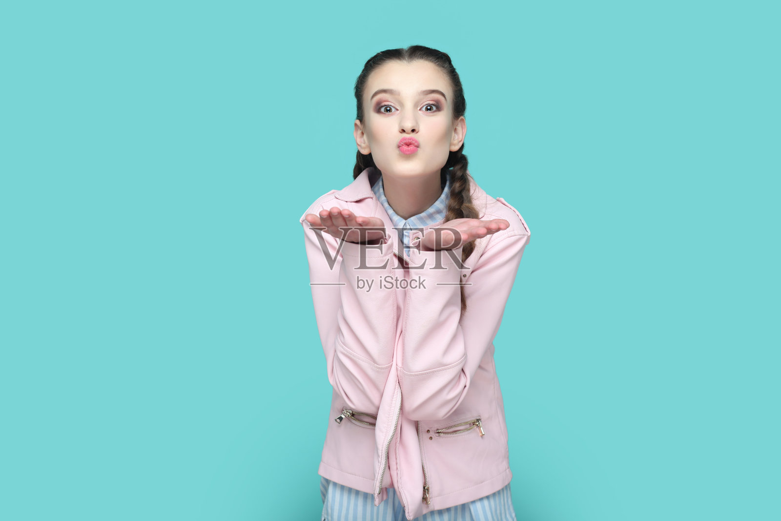 浪漫调情的少女站着表达爱和温柔，在手掌上飞吻。照片摄影图片