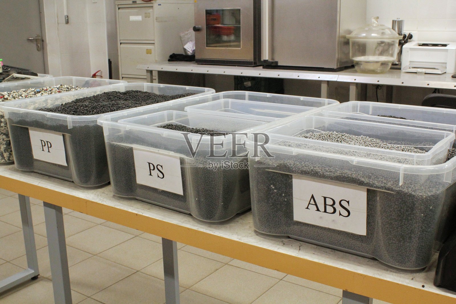 实验室中的灰色染色聚合物树脂。塑料颗粒。从回收的植物聚乙烯复合挤出。可重复使用粉碎物料颗粒。重新研磨工厂的详细信息。生态系统概念照片摄影图片