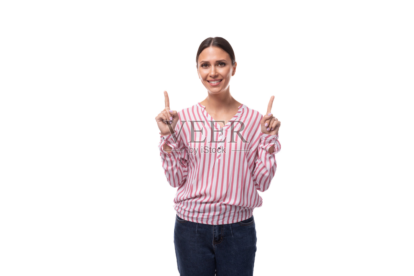 一位年轻苗条的黑发女性，梳着马尾辫，穿着一件在工作室缝制的时髦衬衫照片摄影图片