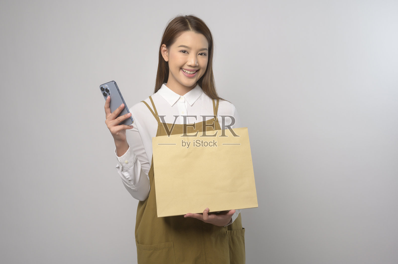 年轻亚洲妇女的肖像穿着围裙在白色背景工作室，烹饪和企业家的概念照片摄影图片