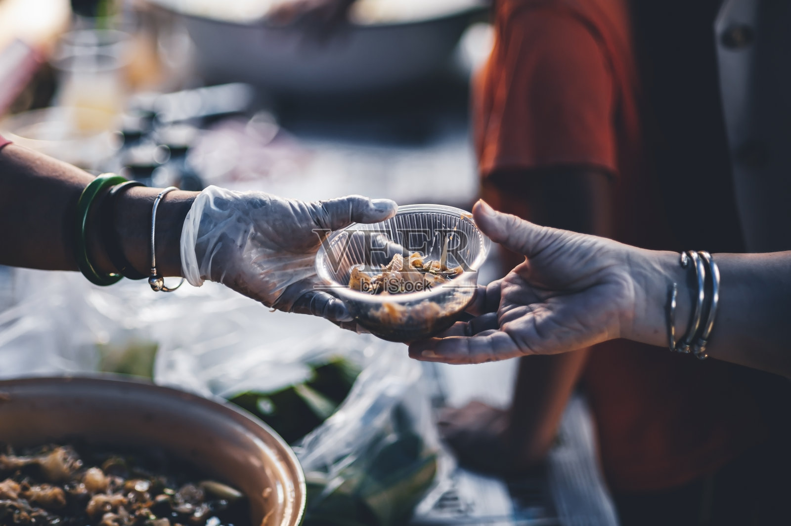 志愿者向无家可归的穷人提供食品援助:公众饥饿的概念。照片摄影图片