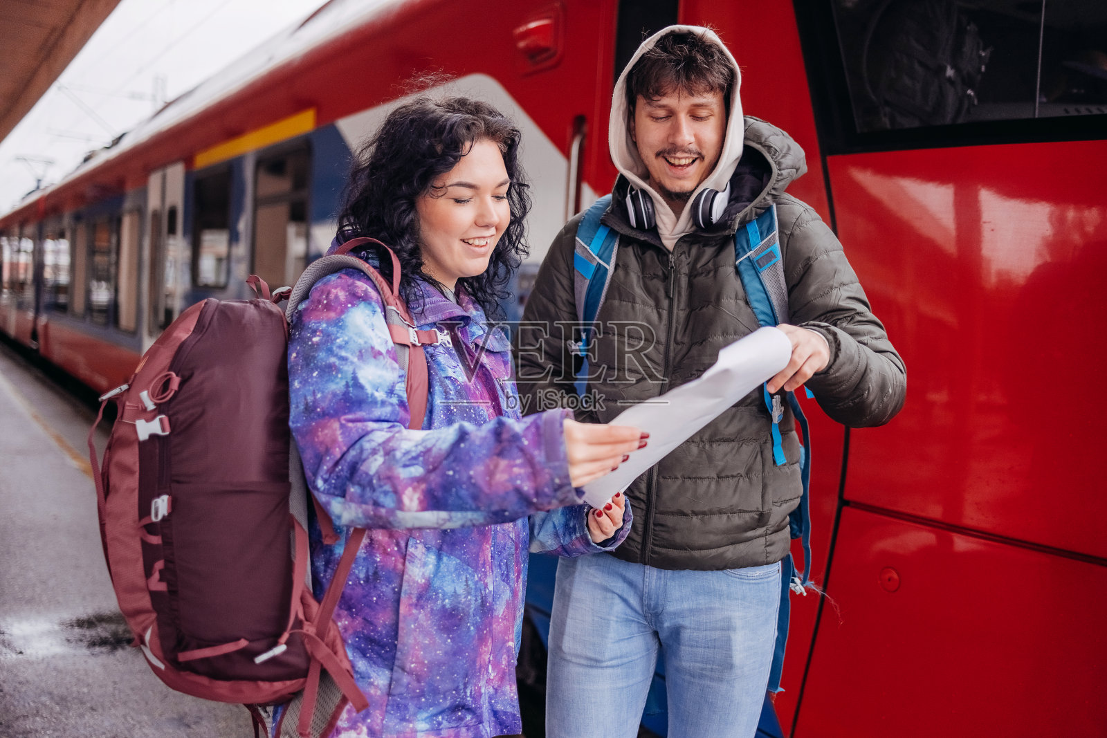 一对年轻夫妇在火车站等车照片摄影图片