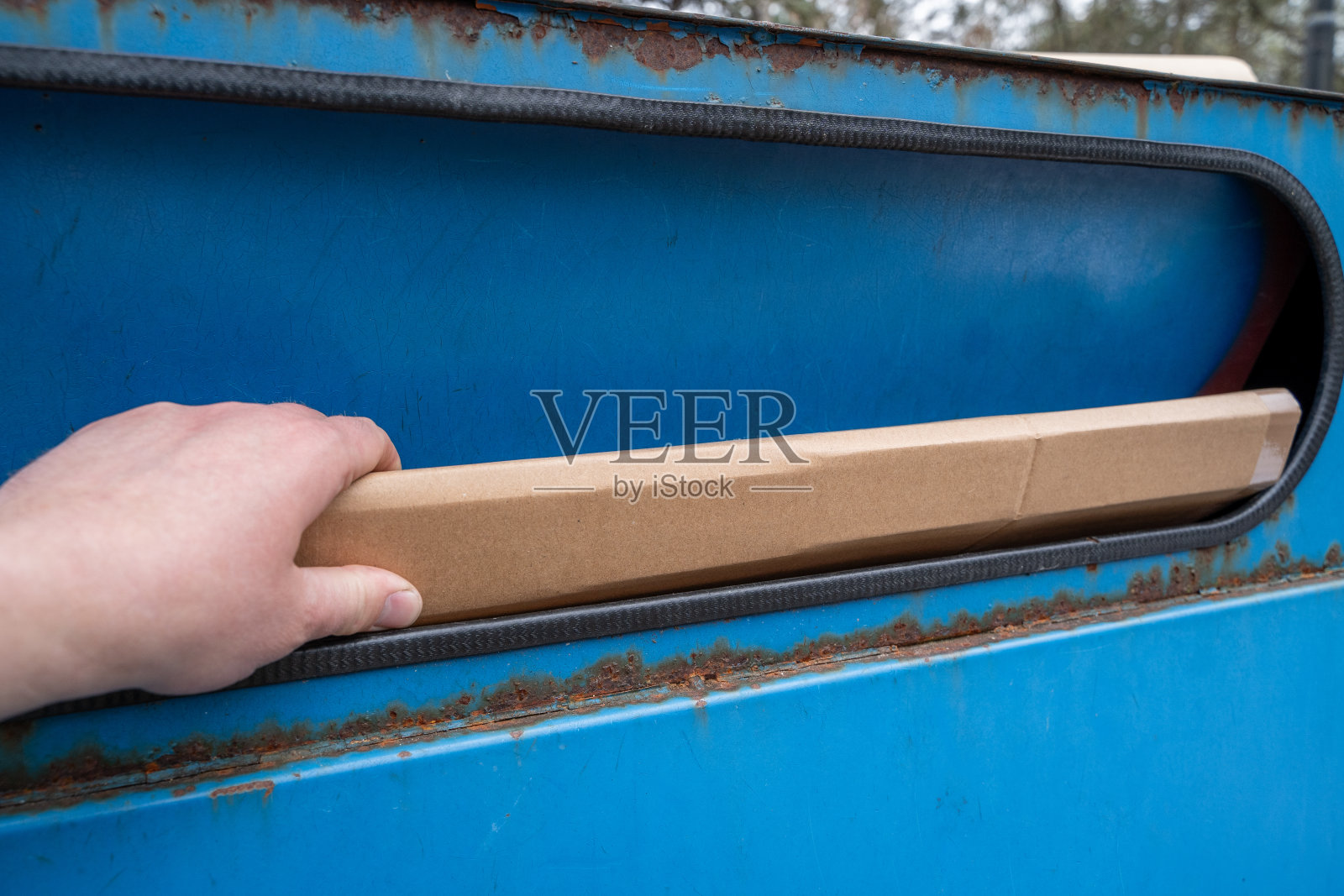 用手把纸板扔向蓝色的纸盒照片摄影图片