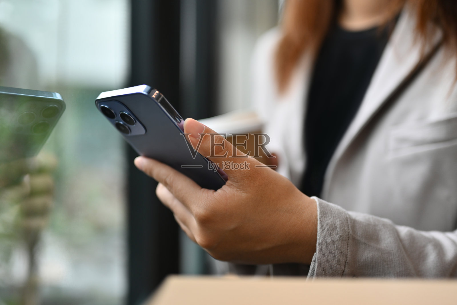 女工坐在窗边发短信，用手机聊天照片摄影图片