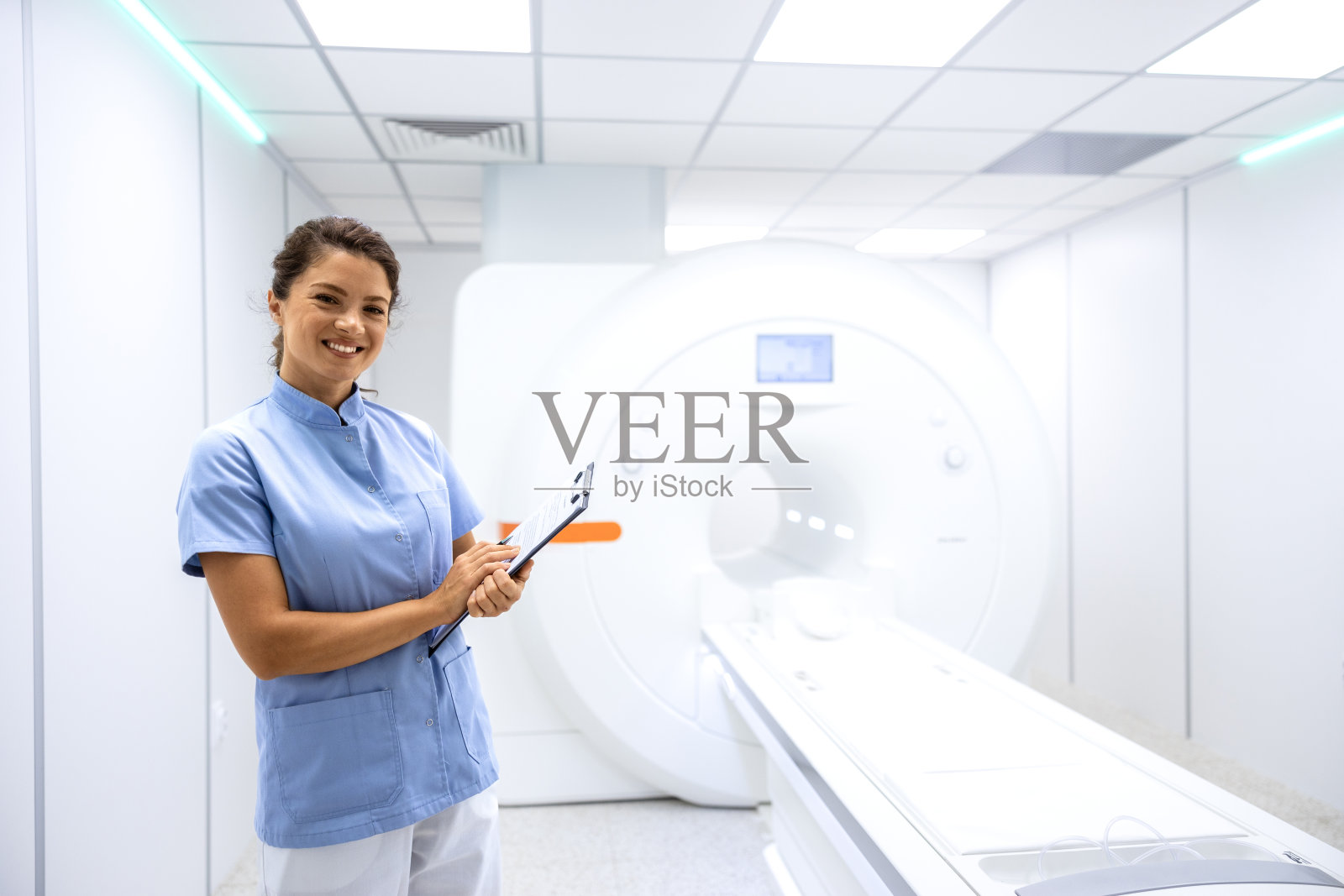 图为站在医院核磁共振诊断室的女放射科医生。照片摄影图片