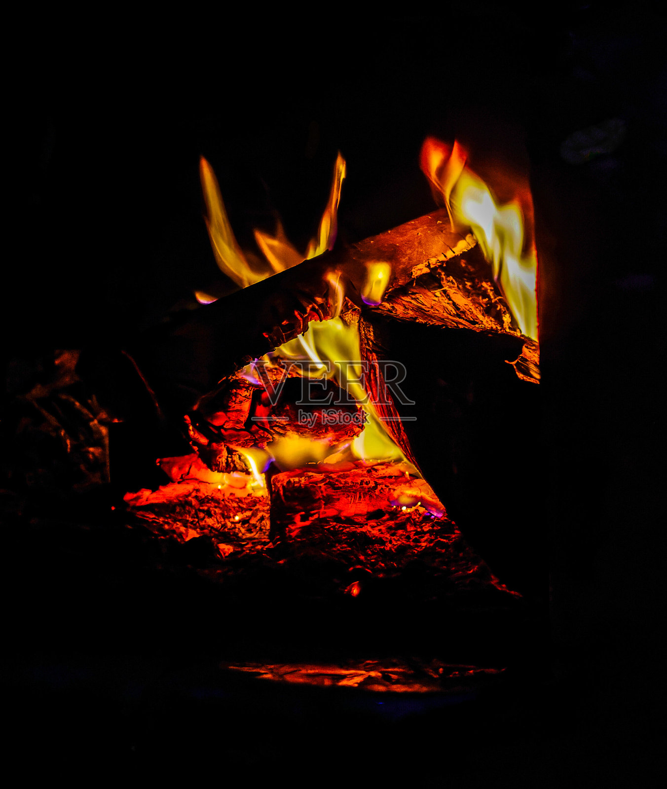 美丽的木头在壁炉里燃烧。非常明显的黄色火焰和炽热的灰烬。照片摄影图片