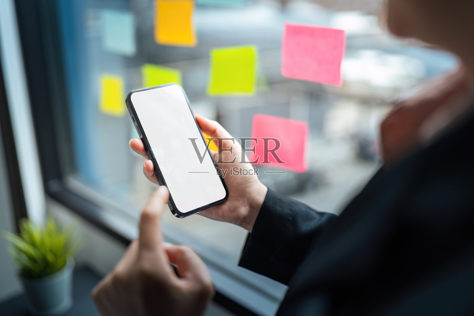 商务女性手持用白色空白屏幕模拟手机进行文字、手机应用设计和广告、网络营销照片摄影图片