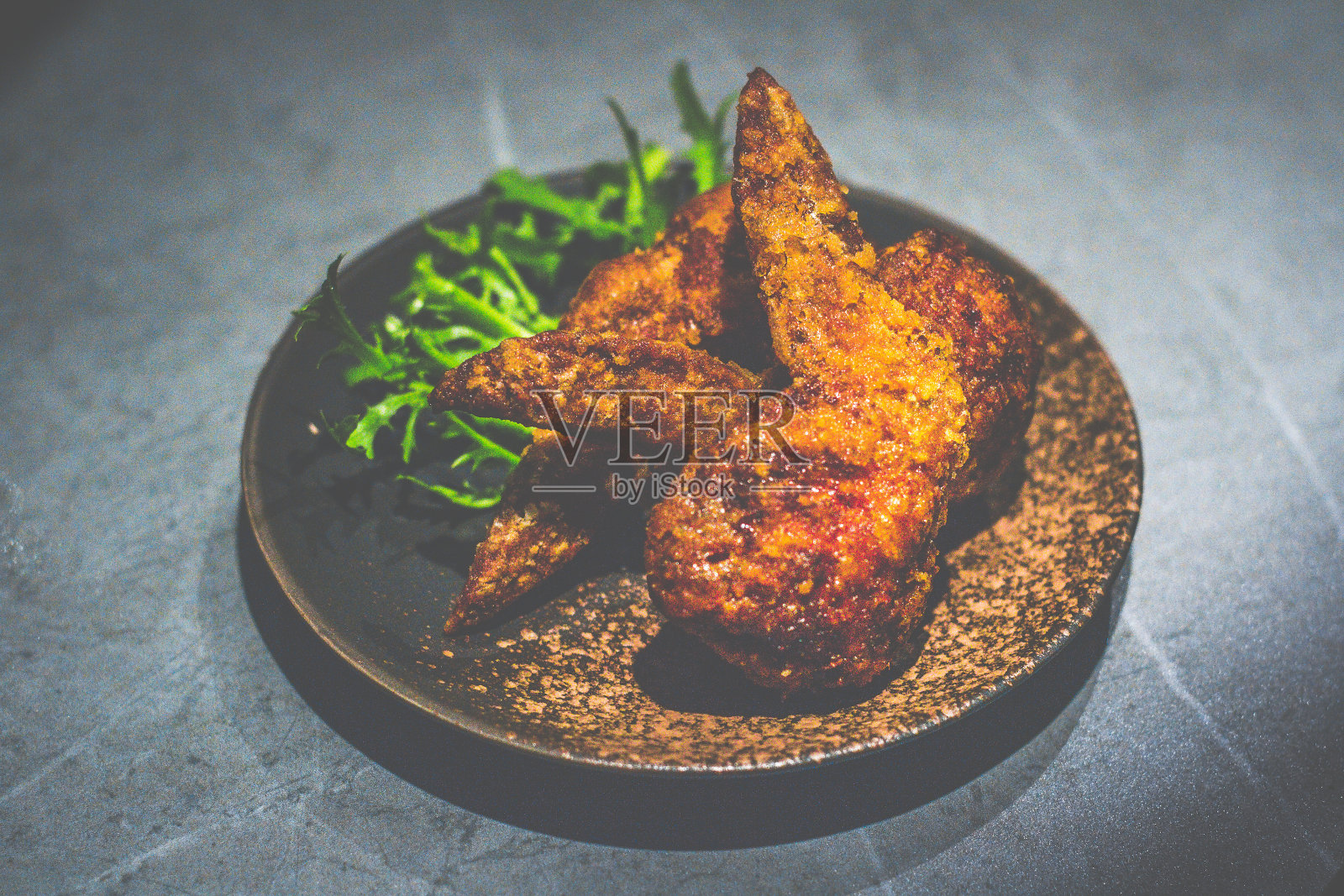 鸡翅饺子：鸡翅、猪肉末、卷心菜组合，盛在黑色小盘中照片摄影图片