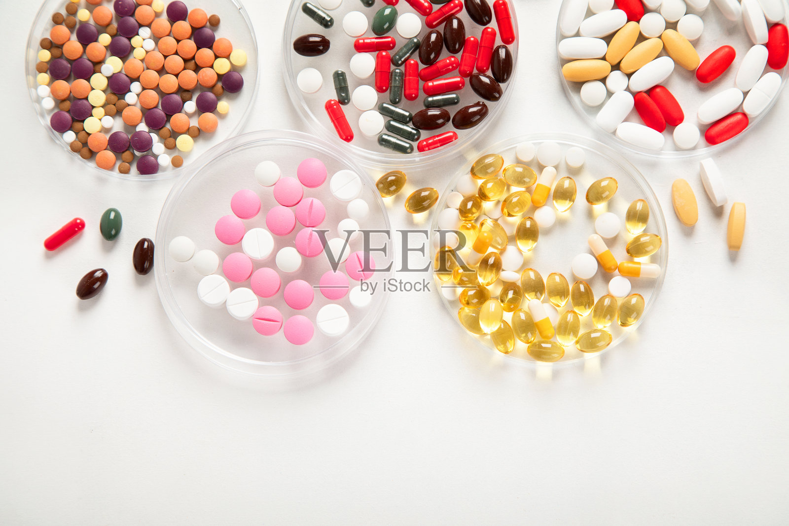 白色背景上不同的药片和听诊器。医学的概念照片摄影图片