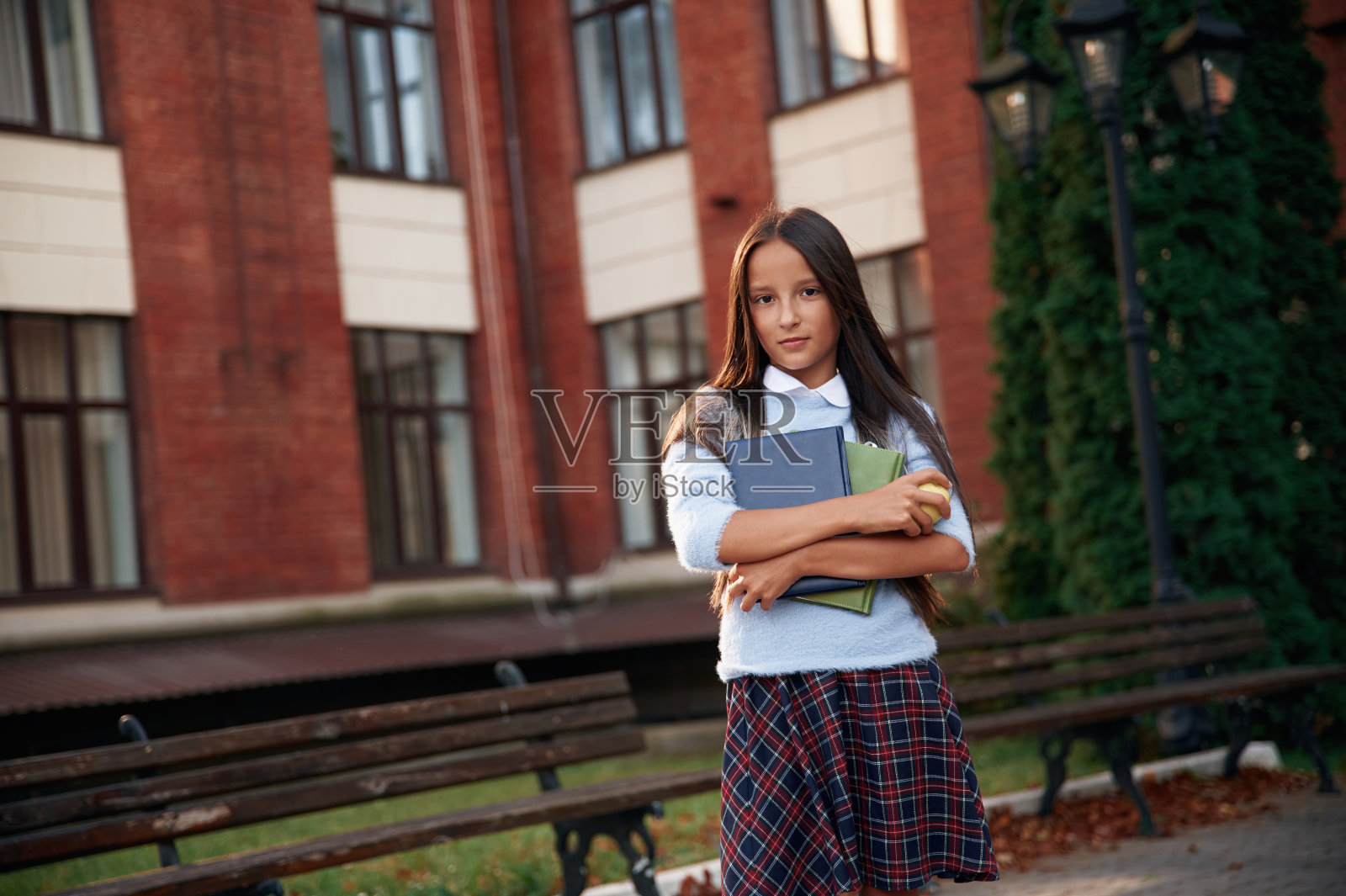 穿着制服，反对建筑。女学生在户外照片摄影图片