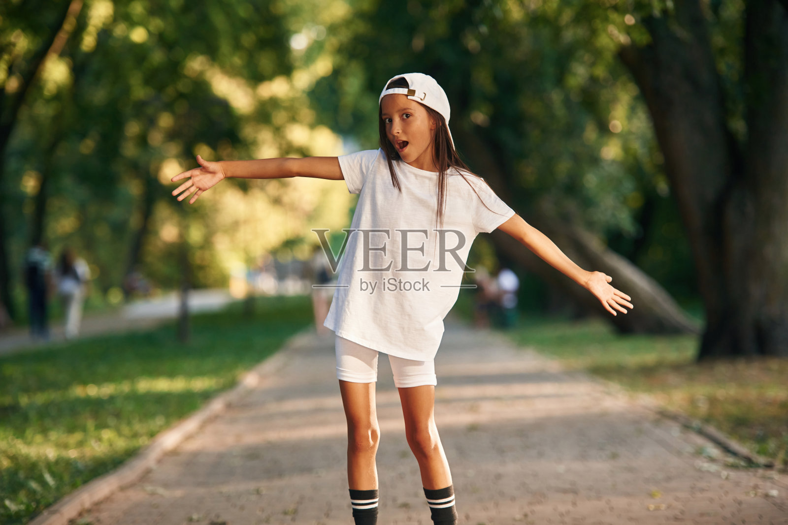 顽皮的面部表情。穿着便服的年轻女孩在公园外面照片摄影图片