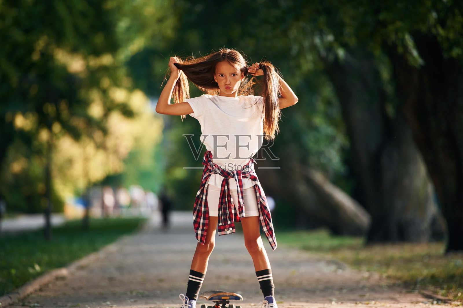 玩头发，疯了。快乐的小女孩在户外玩滑板照片摄影图片