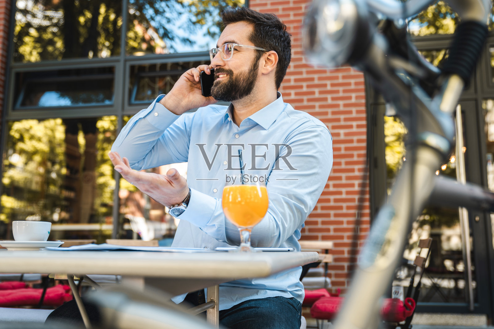 年轻的现代企业家坐在户外打电话照片摄影图片