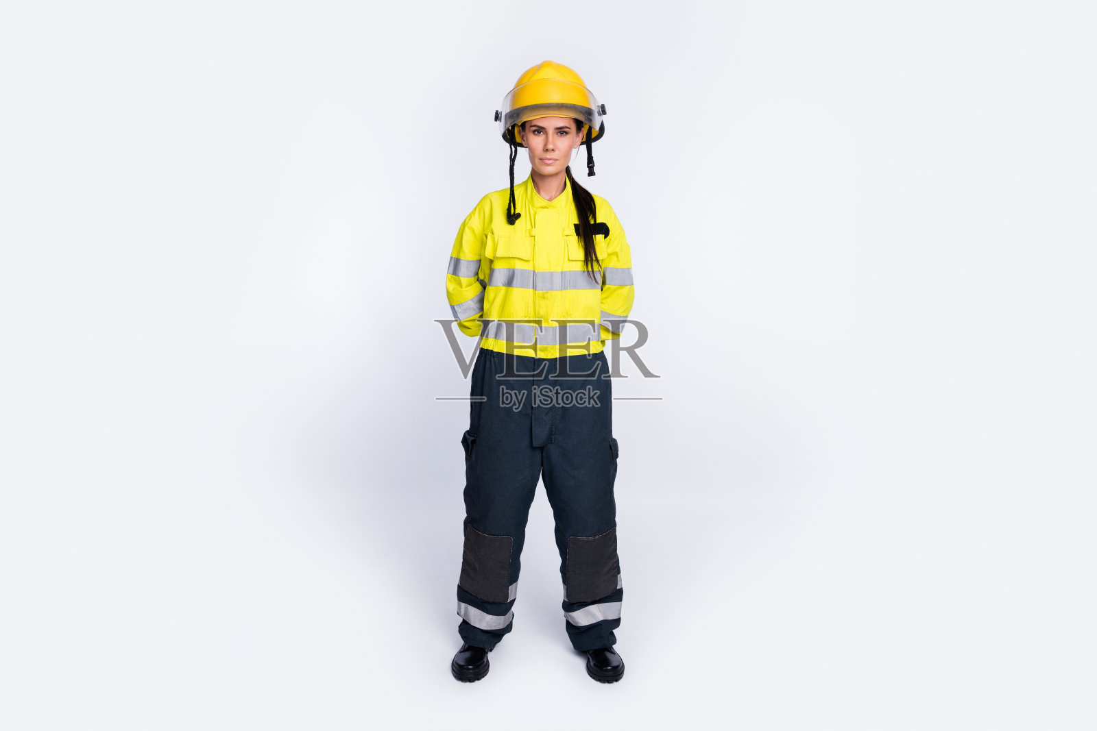 年轻迷人的女消防员的全身照片，严肃自信地穿着白色背景上孤立的制服照片摄影图片